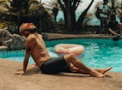 Man enjoying a sunny day by the pool in Quito, Ecuador. Perfect for summer vibes and relaxation themes.