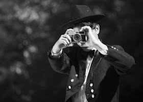 Vintage-style black and white portrait of a man holding a camera in Buenos Aires.